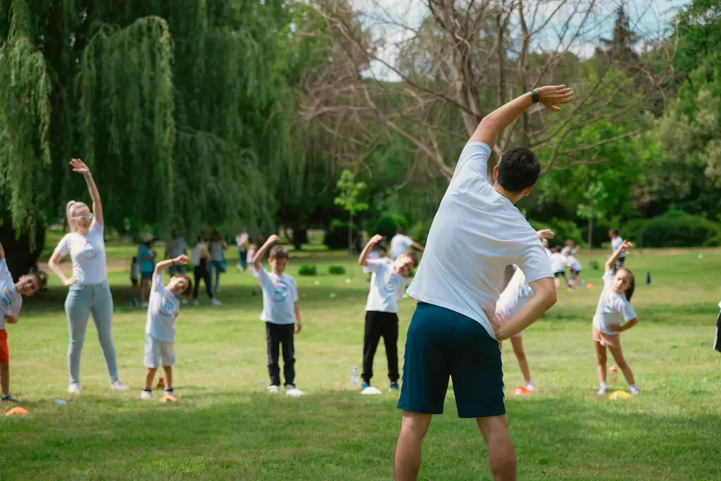 a teacher showing children stretches during a pe lesson