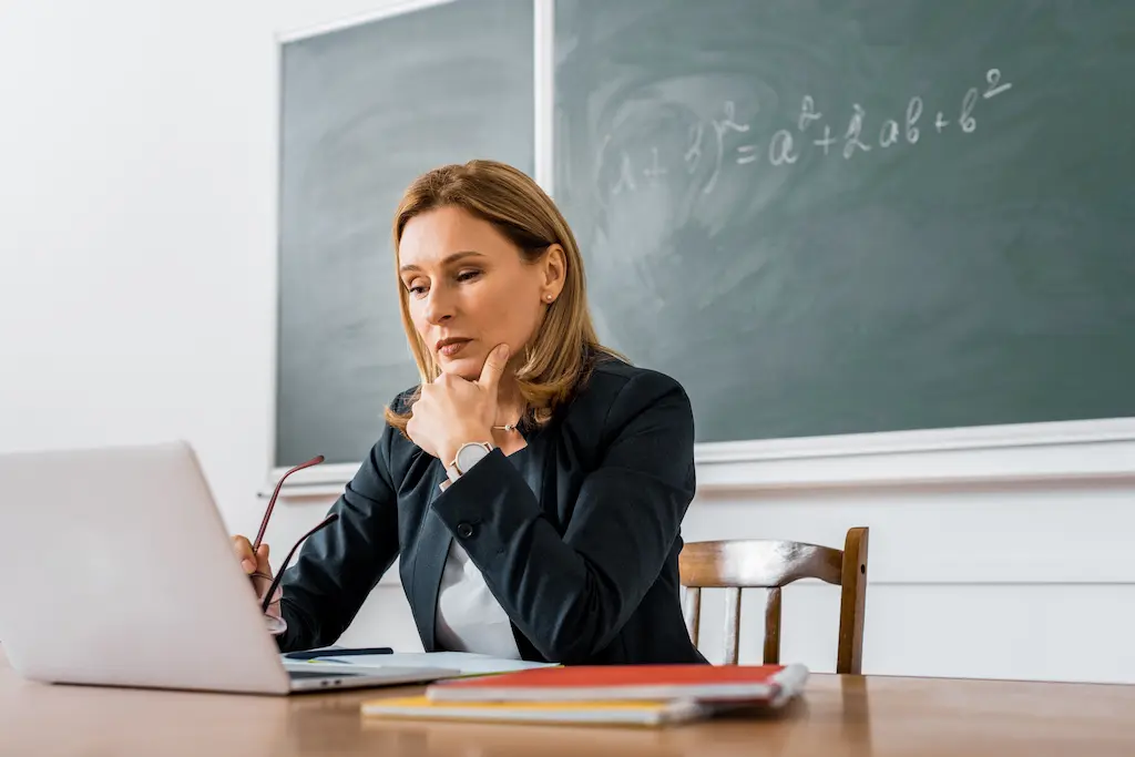 a teacher using a computer with childcare software in a classroom