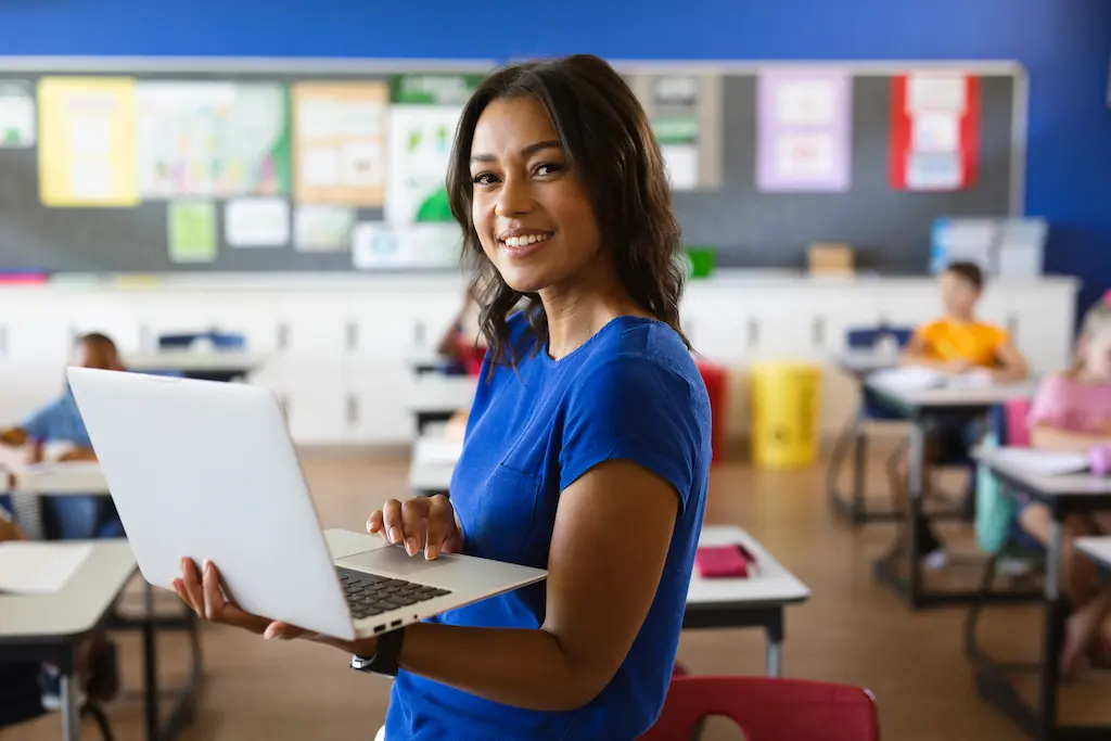 a teacher smiling using software for childcare in her class